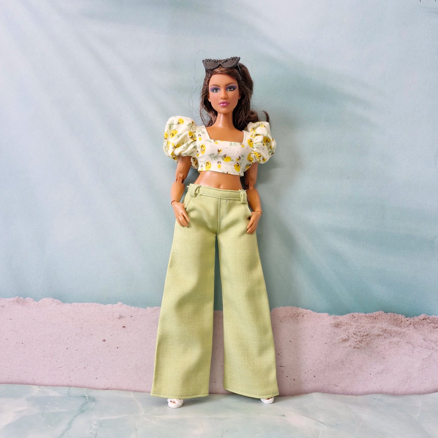 Summer doll fashion featuring a yellow flower print puff sleeve top and pastel green pants designed for Curvy Barbie.