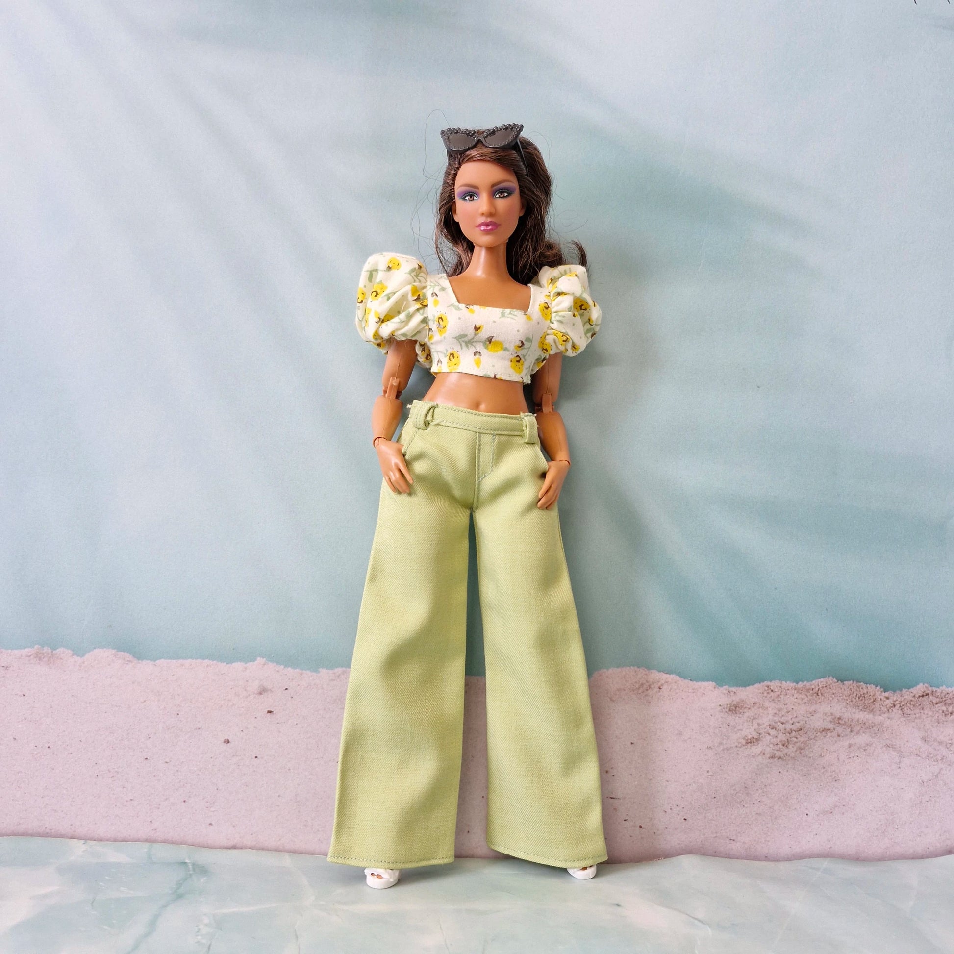 Summer doll fashion featuring a yellow flower print puff sleeve top and pastel green pants designed for Curvy Barbie.