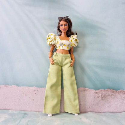 Summer doll fashion featuring a yellow flower print puff sleeve top and pastel green pants designed for Curvy Barbie.