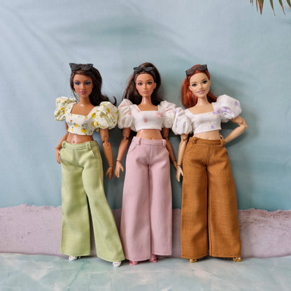 Group of three Curvy Barbie dolls modeling mix and match floral crop tops and wide leg pants in green, pink, and brown.