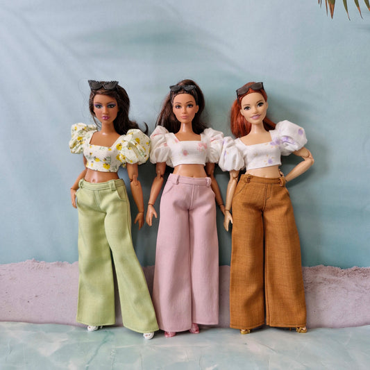 Group of three Curvy Barbie dolls modeling mix and match floral crop tops and wide leg pants in green, pink, and brown.