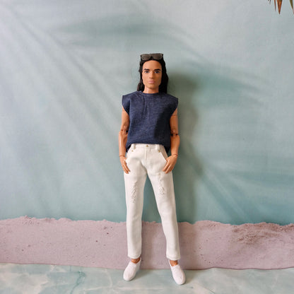 Full body shot of a Ken doll wearing a navy sleeveless top, white distressed jeans, and white sneakers.
