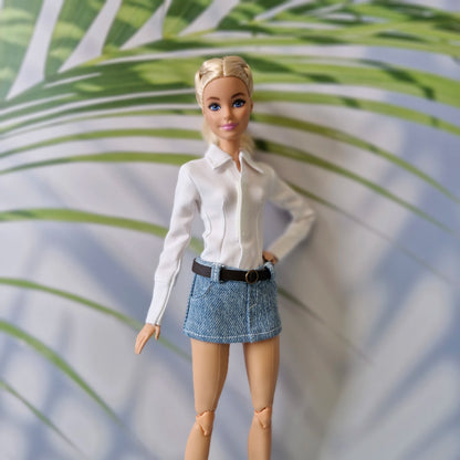 Barbie doll showcasing a versatile everyday outfit with a white long-sleeve shirt and belted denim skirt.