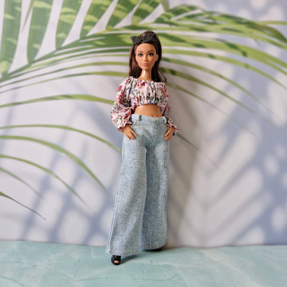 Full body view of a Curvy Barbie doll in a stylish off-shoulder floral top and light blue wide-leg jeans.