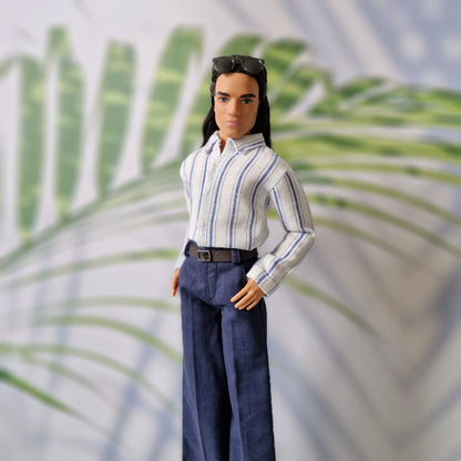 Close-up of a Ken doll modeling a miniature white shirt with blue vertical stripes and navy blue pants with a belt.