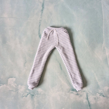 Flat lay of tapered doll sweatpants in a light blue and white striped pattern with a drawstring waist.