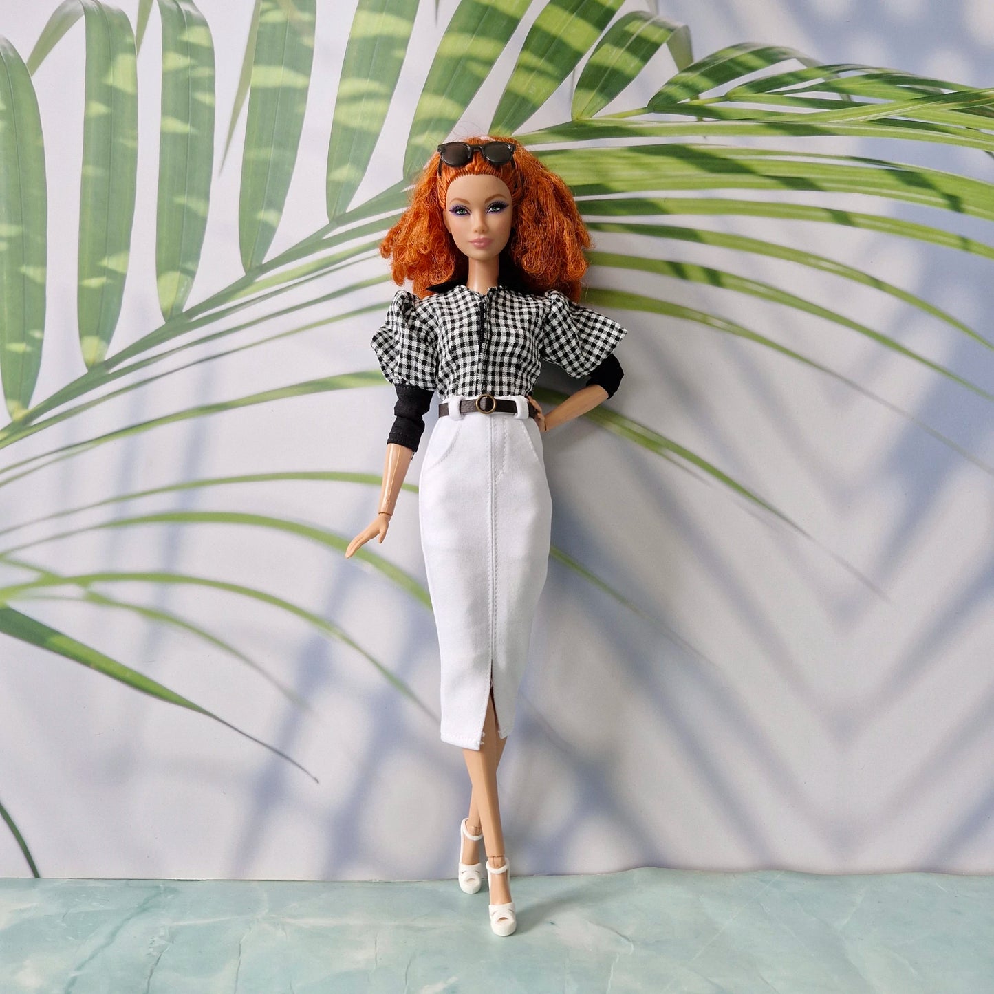 Redhead fashion doll modeling chic clothes for Barbie: a black and white gingham top and a white pencil skirt with a front slit and belt.