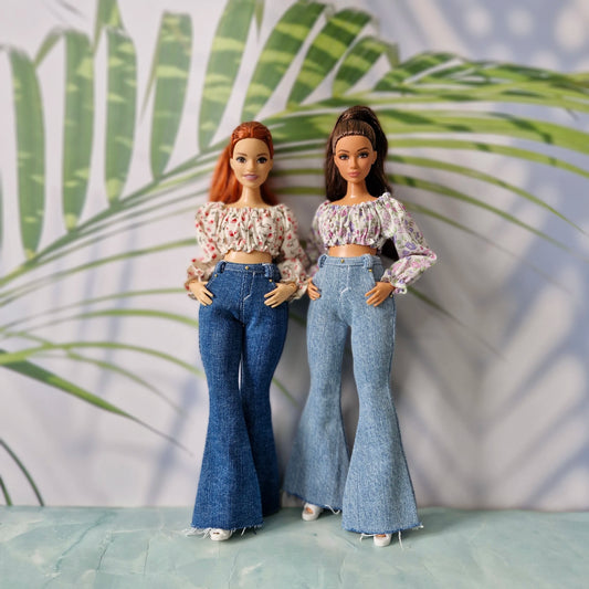 Two curvy fashion dolls standing together, modeling floral tops and flared jeans outfits for Curvy Barbie.