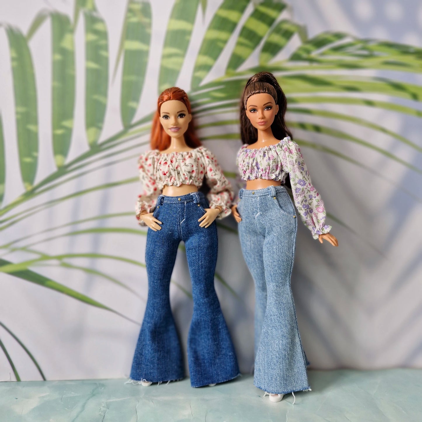Twin dolls showcasing mix and match floral crop tops and denim bell-bottom clothes for Curvy Barbie.