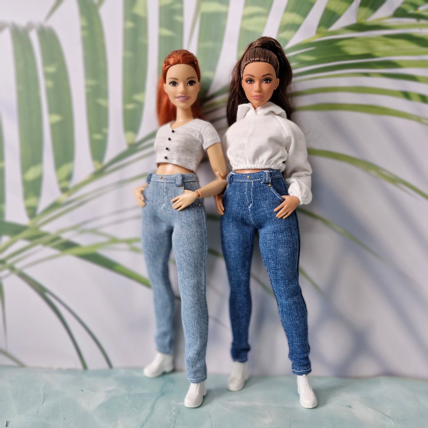 Twin curvy dolls wearing mix and match white hoodies, grey tops, and denim jeans for Curvy Barbie.