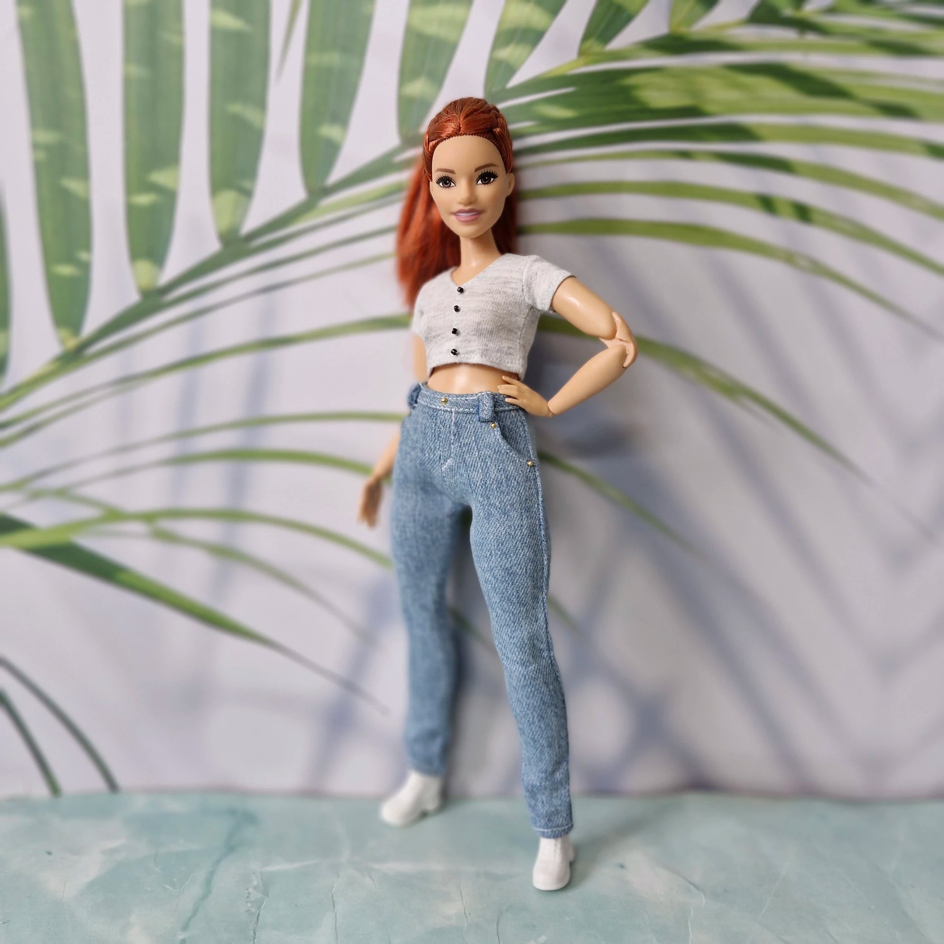 Stylish doll wearing casual 11.5-inch doll clothes including a grey crop top and light jeans for Curvy Barbie.