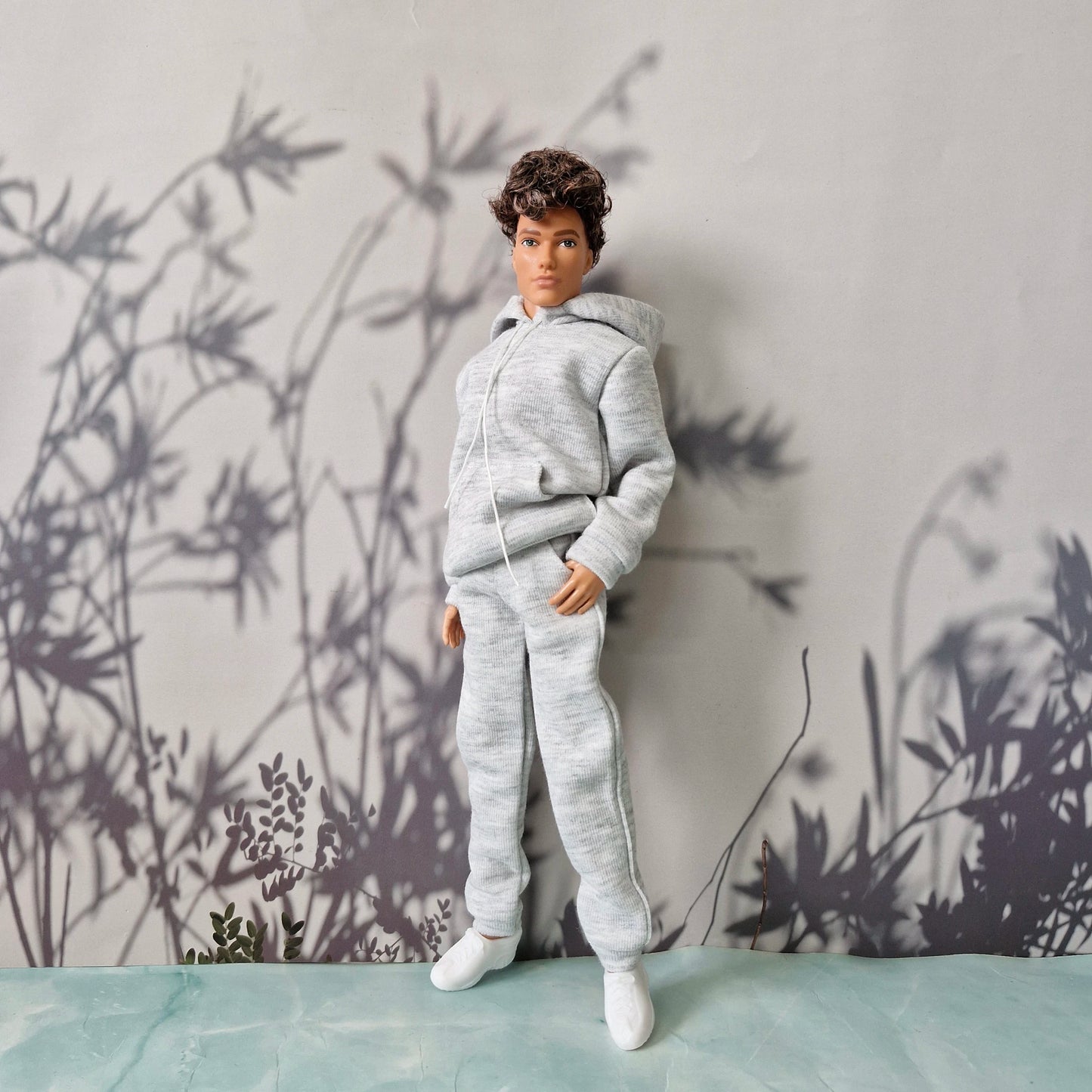 Ken doll wearing a casual grey heather hoodie and matching sweatpants for Ken.