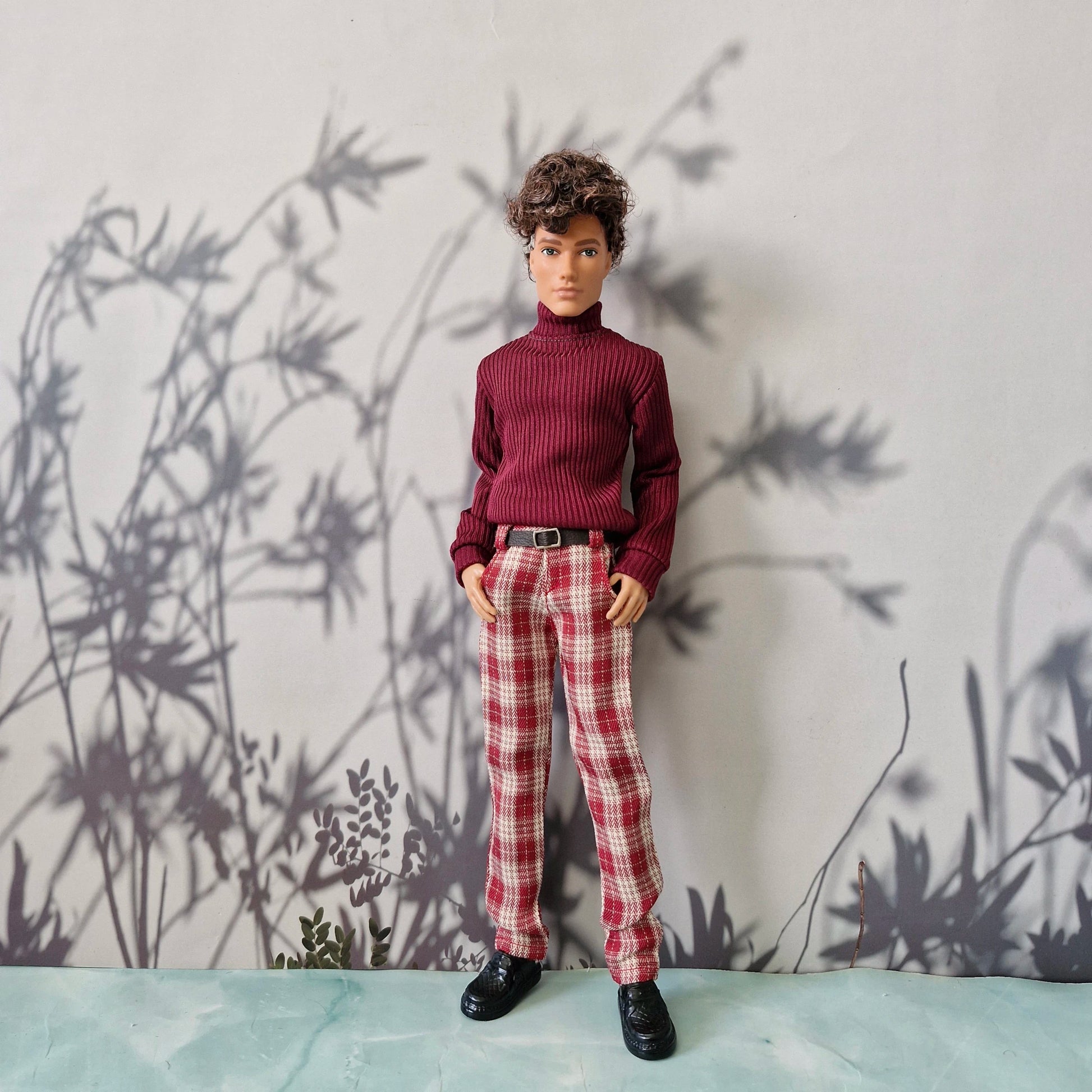 Ken doll dressed in a burgundy red turtleneck sweater and red plaid trousers for Ken.