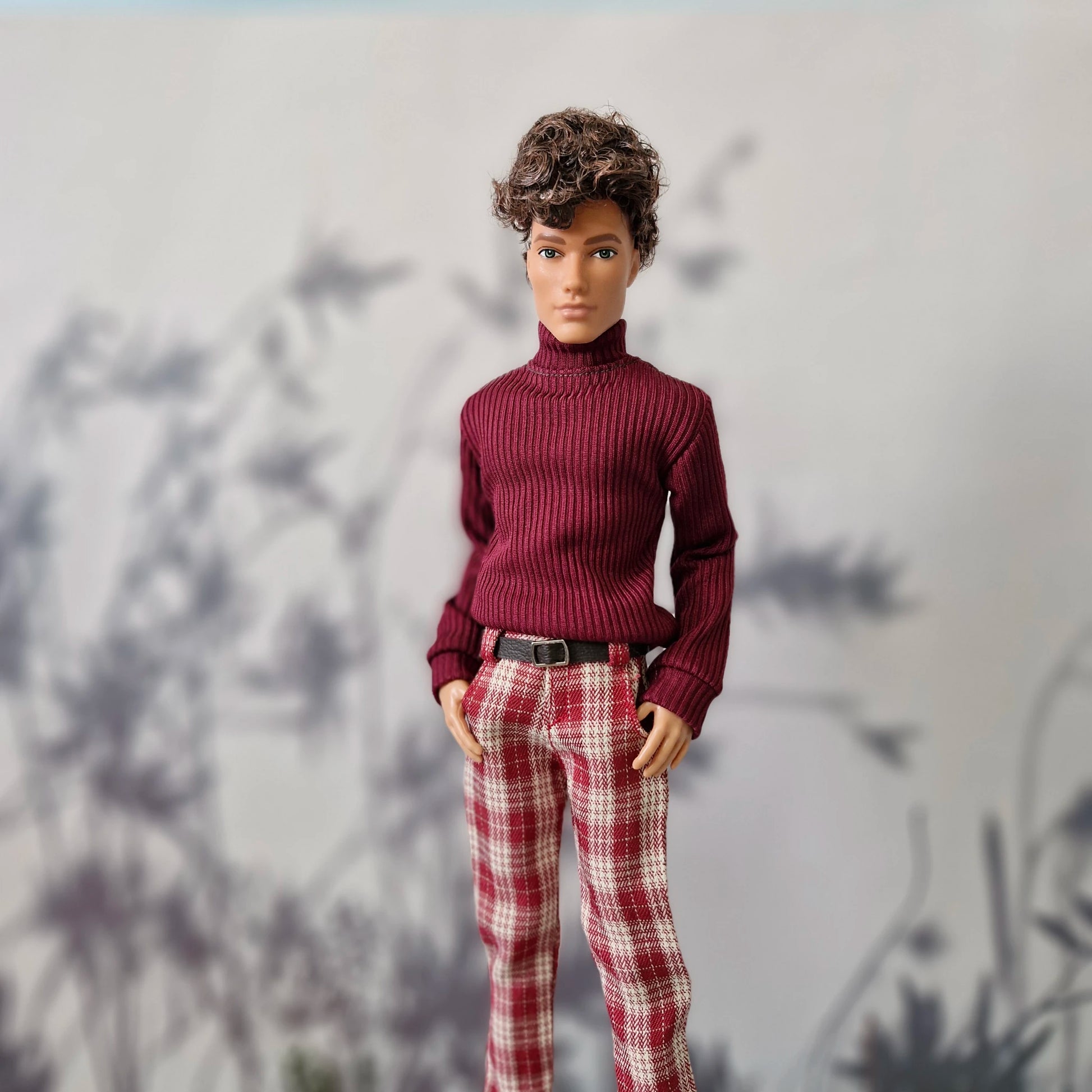 Handsome doll modeling a dark red ribbed sweater and red plaid pants outfit for Ken.
