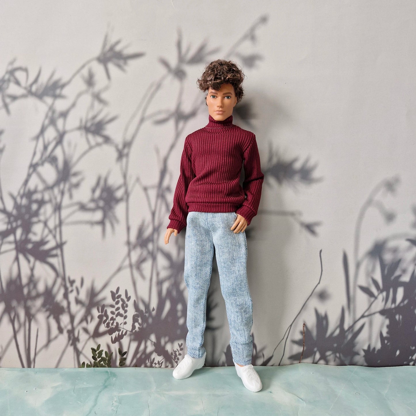 Trendy fall and winter clothes featuring a dark red ribbed sweater and denim pants for Ken.