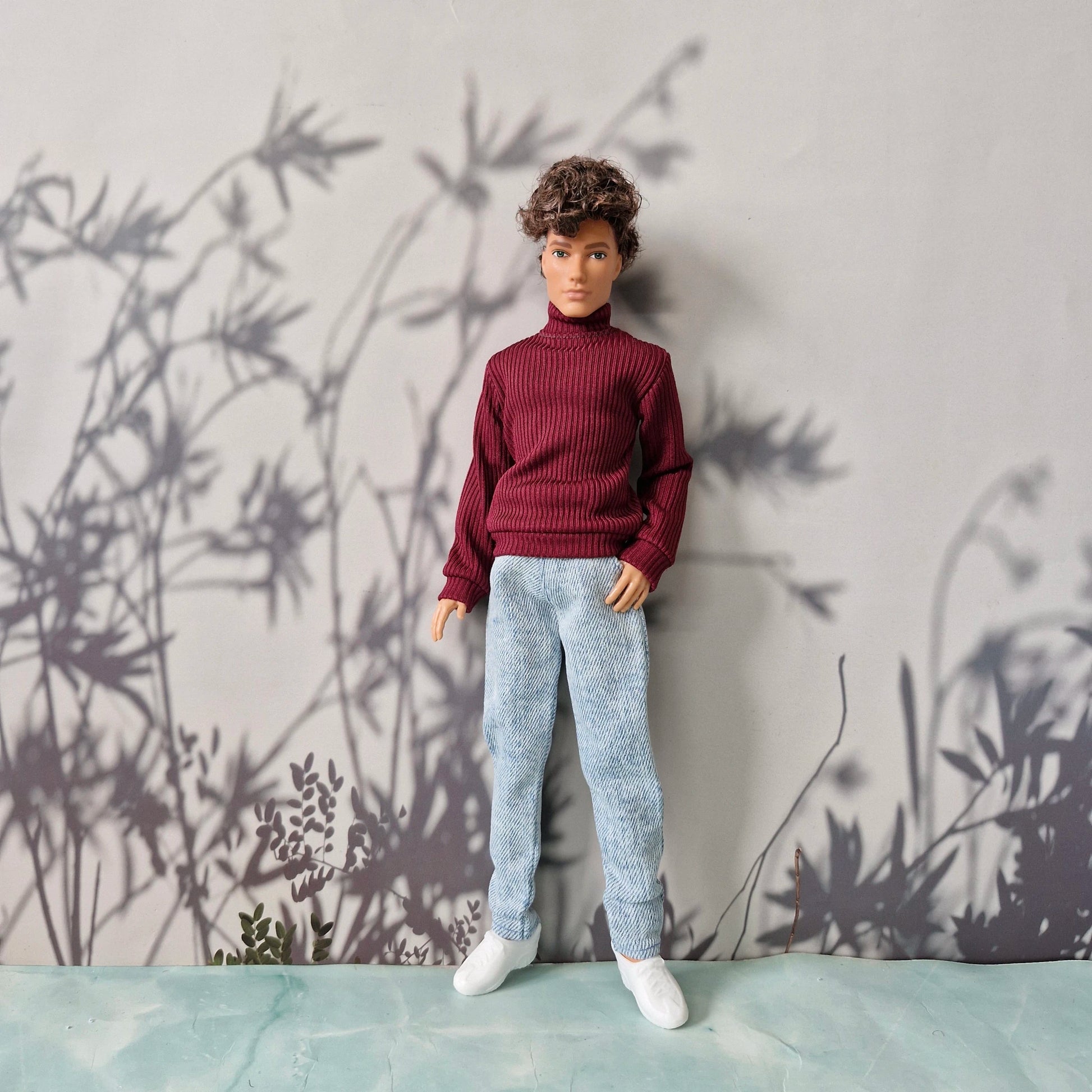 Trendy fall and winter clothes featuring a dark red ribbed sweater and denim pants for Ken.