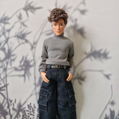 Ken doll wearing a grey ribbed turtleneck sweater and dark denim cargo pants for Ken.
