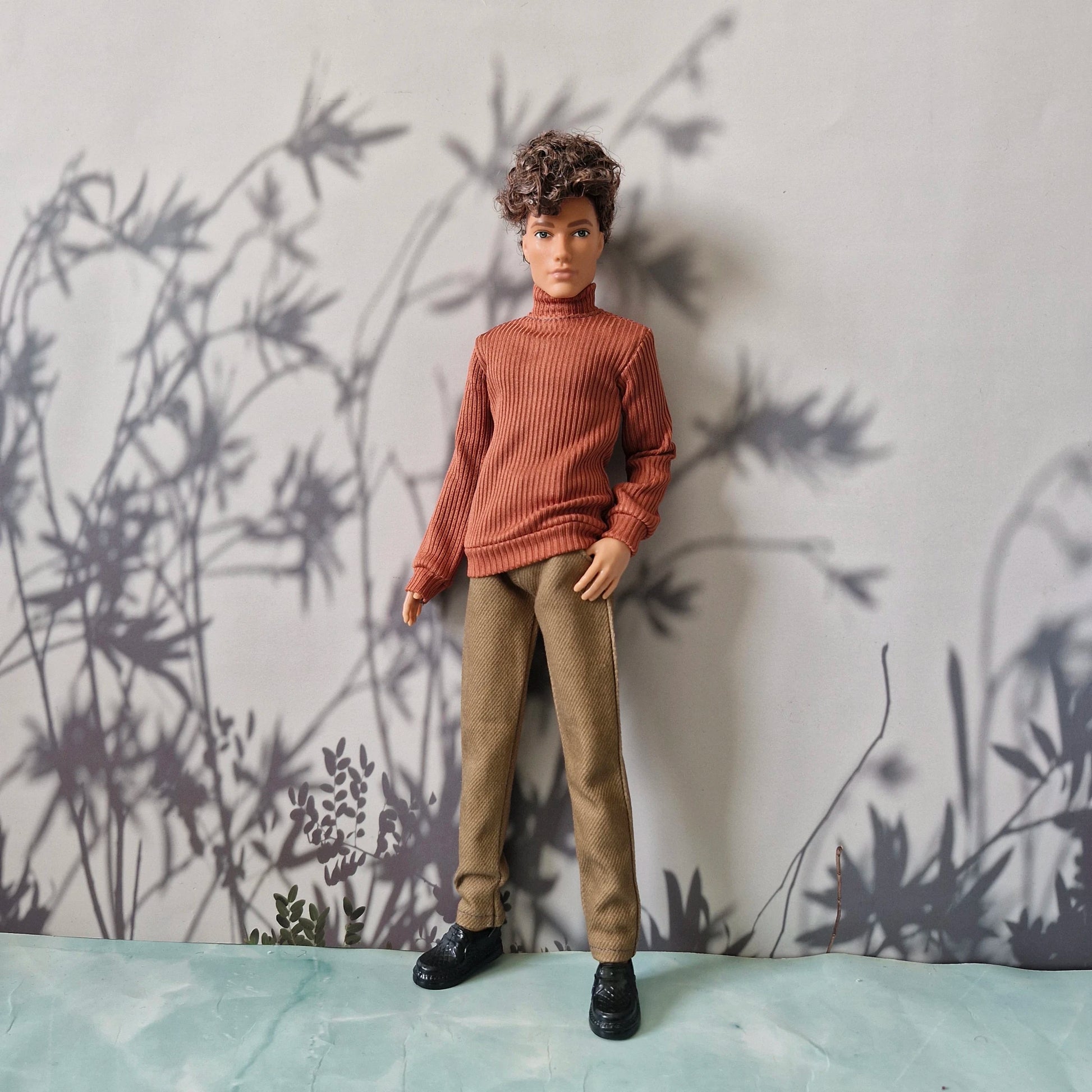 Casual everyday fashion showing an orange turtleneck, solid khaki pants, and black shoes for Ken.