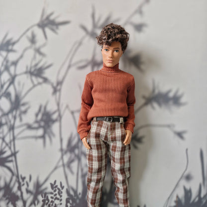 Ken doll modeling a brown ribbed turtleneck sweater and brown plaid pants for Ken.