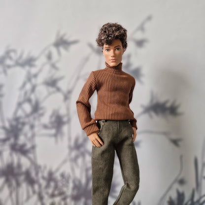 Ken doll wearing a brown long-sleeve ribbed turtleneck sweater and plain olive green pants for Ken.
