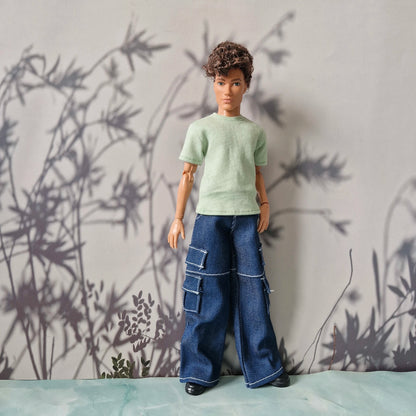 Full body shot of a male doll in a green t-shirt and stylish blue cargo jeans for Ken.