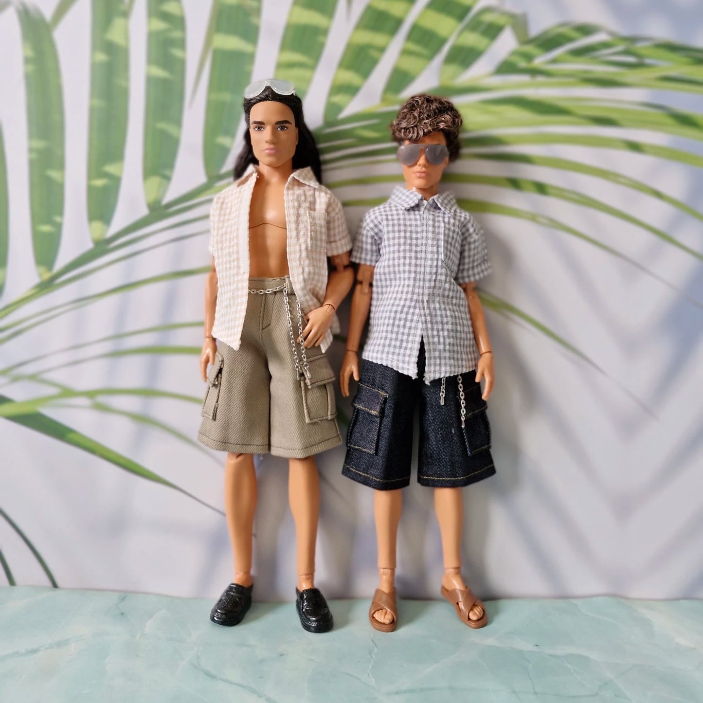Two male dolls standing together modeling mix and match gingham shirts and cargo shorts separates for Ken.