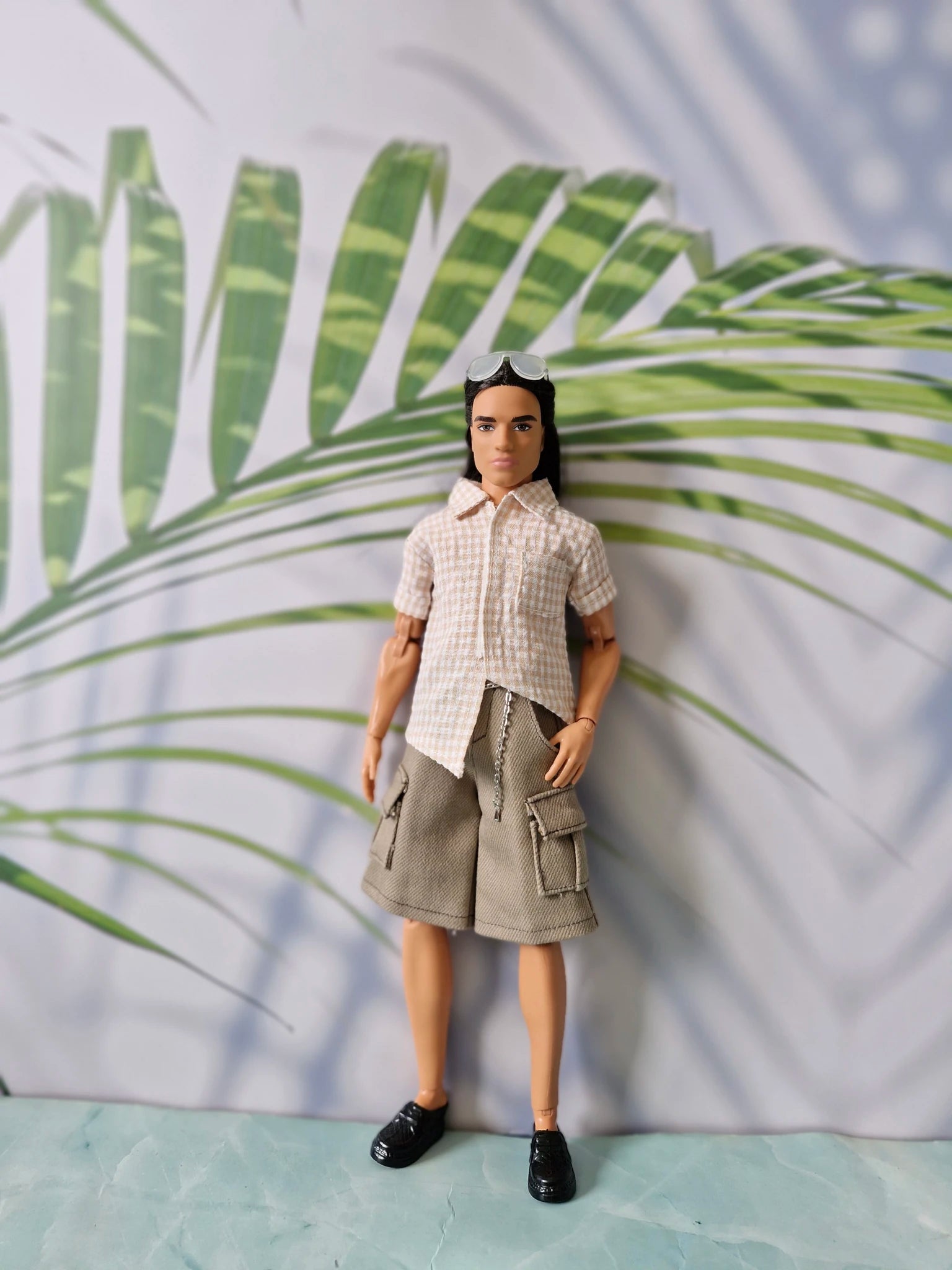Boy fashion doll wearing a neatly buttoned beige gingham shirt and khaki cargo shorts for Ken.