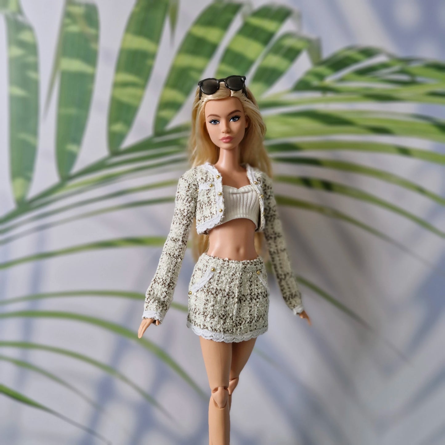 11.5 inch fashion doll wearing a chic cream tweed 3-piece skirt set for Barbie against a tropical palm background.
