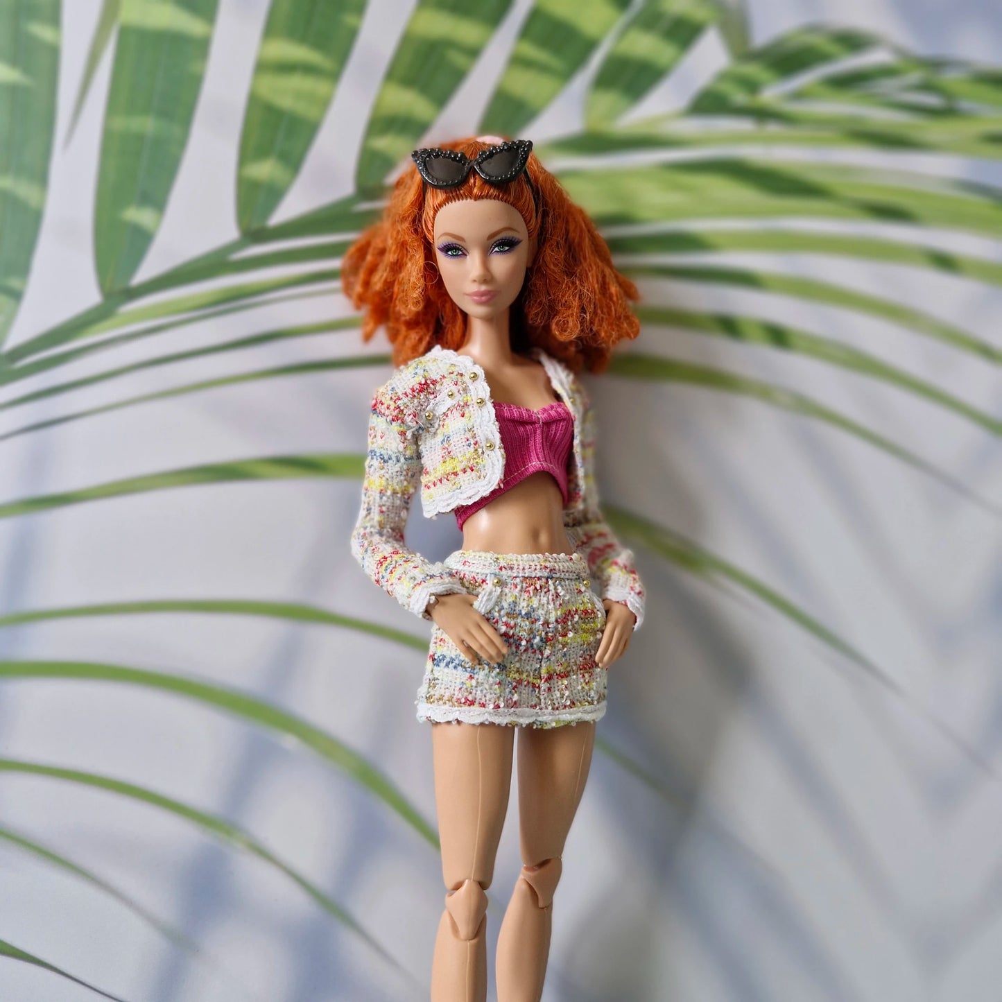 Close up of a redhead Curvy Barbie wearing a colorful tweed outfit for Barbie featuring gold button details.