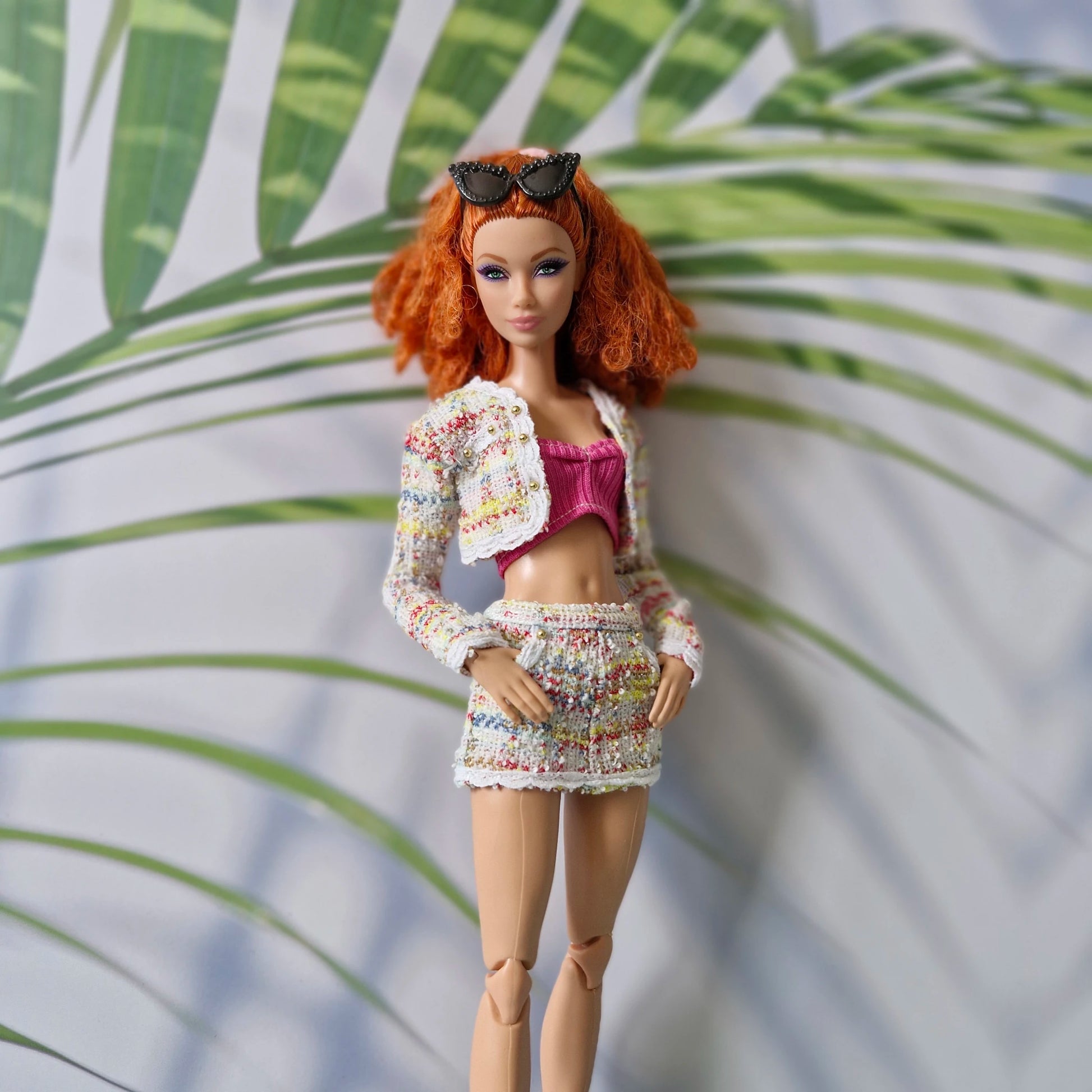 Close up of a redhead Curvy Barbie wearing a colorful tweed outfit for Barbie featuring gold button details.