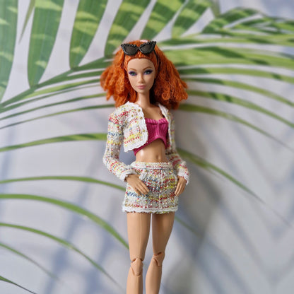 Close up of a redhead Curvy Barbie wearing a colorful tweed outfit for Barbie featuring gold button details.