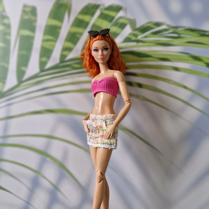 Curvy Barbie doll dressed in a bright pink ribbed crop top and multicolor tweed mini skirt for Barbie.