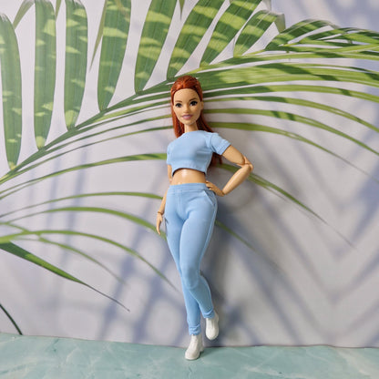11.5 inch fashion doll modeling a light blue ribbed crop top and pants sold separately for Barbie.