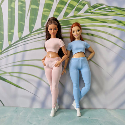 Two fashion dolls wearing fitted ribbed knit loungewear sets in light pink and blue for Barbie and for Curvy.