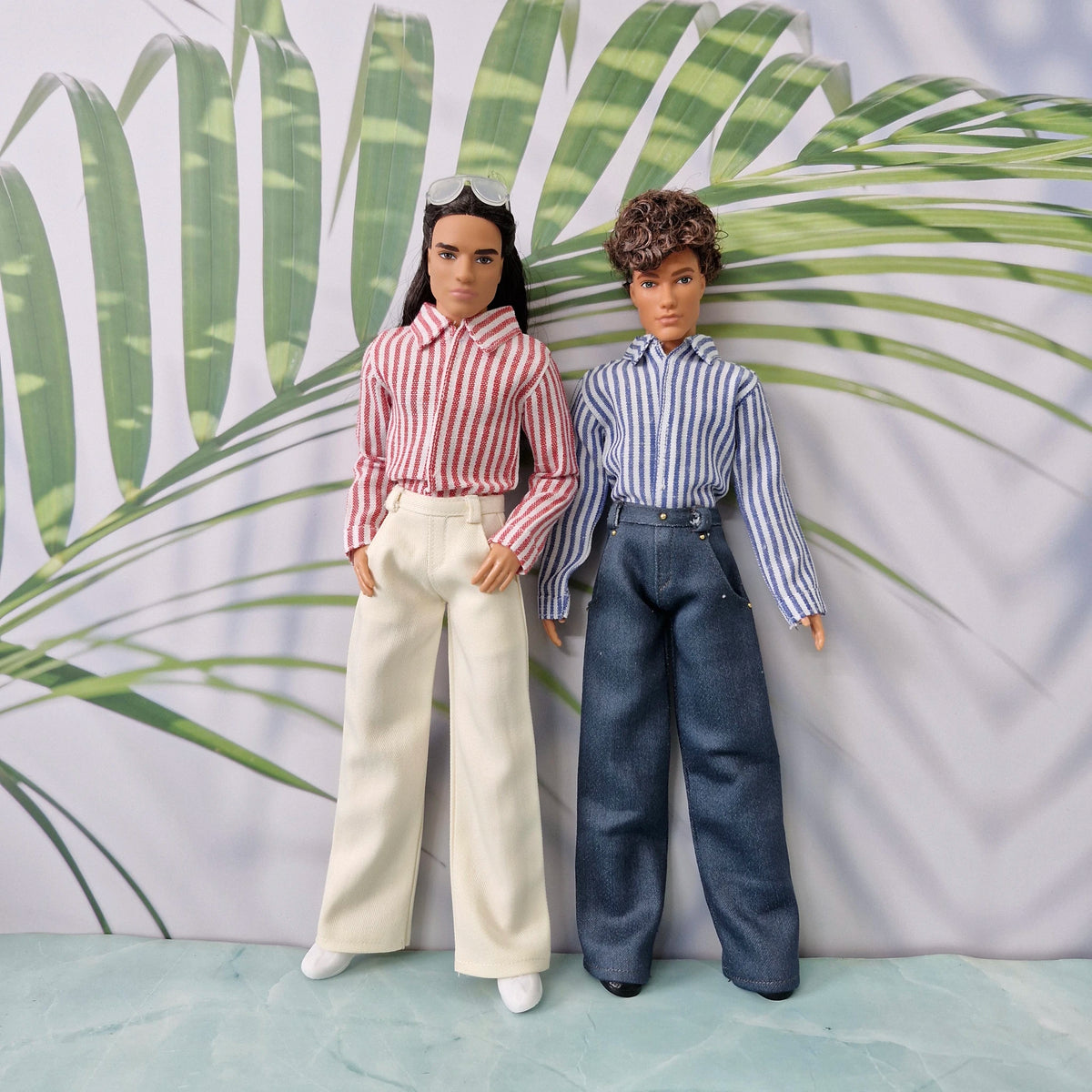 Full body view of two Ken dolls modeling custom handmade striped shirts and wide-leg pants.