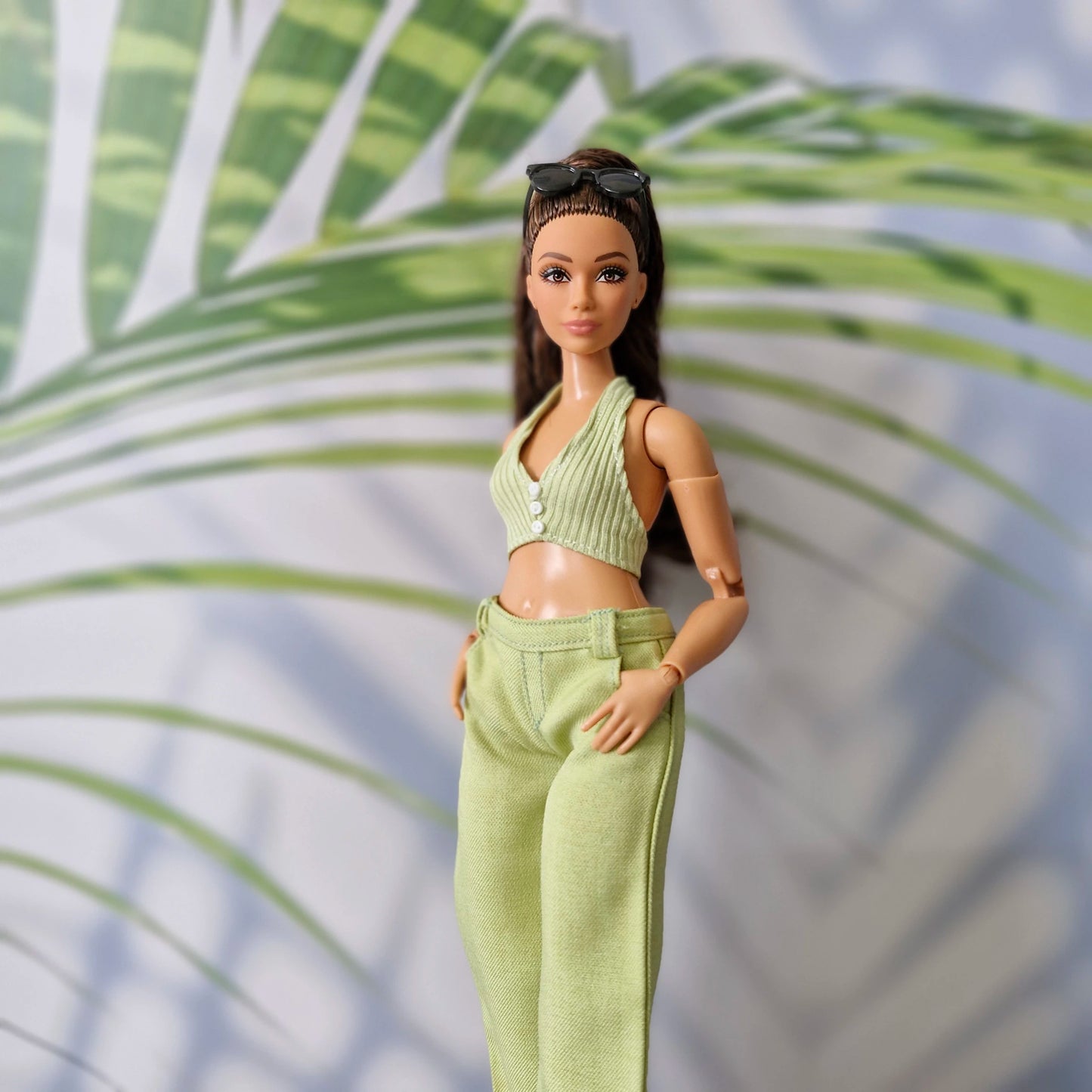 Close up of a Curvy Barbie doll wearing a handmade light green ribbed halter top and matching green pants.