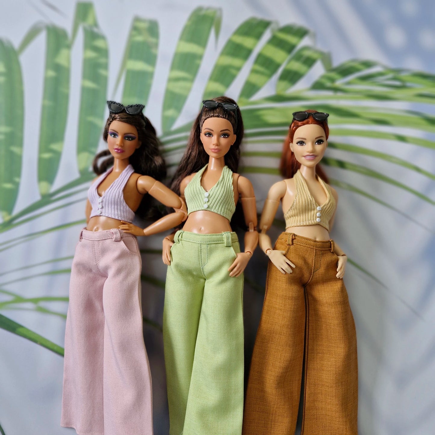 Close up of three Curvy Barbie dolls modeling custom handmade mix and match halter tops and trousers.