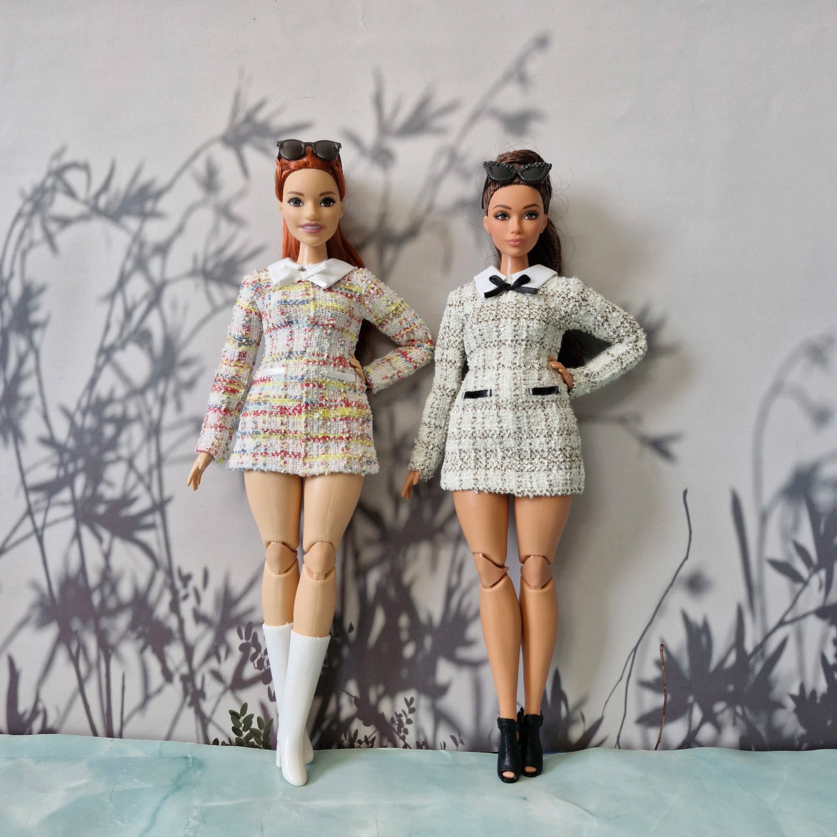 Curvy and standard Barbie dolls modeling handmade long-sleeve tweed dresses in colorful and black-and-white patterns.
