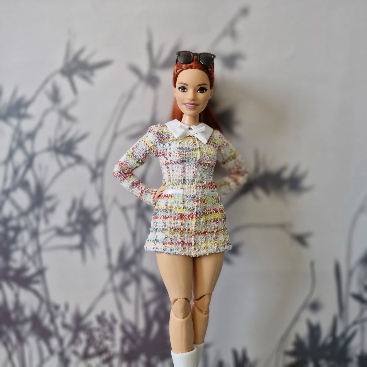 Curvy Barbie doll posing in a handmade multi-color pastel tweed dress with a white collar.