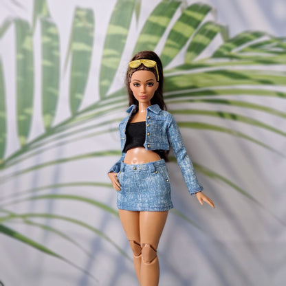 Brunette Curvy Barbie doll posing in a custom handmade light blue denim jacket and mini skirt with a black tube top.