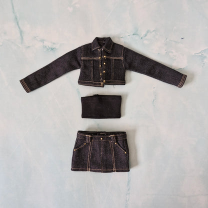 Flat lay of a handmade dark denim Curvy doll clothing set including a cropped jacket, black tube top, and mini skirt.
