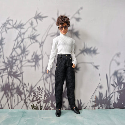 Full body shot of a Ken doll wearing a classic white ribbed turtleneck top and dark wash denim jeans.