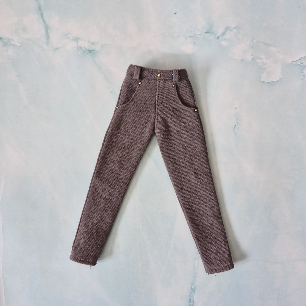 Flat lay of handmade 1/6 scale tailored grey denim jeans for Ken dolls.