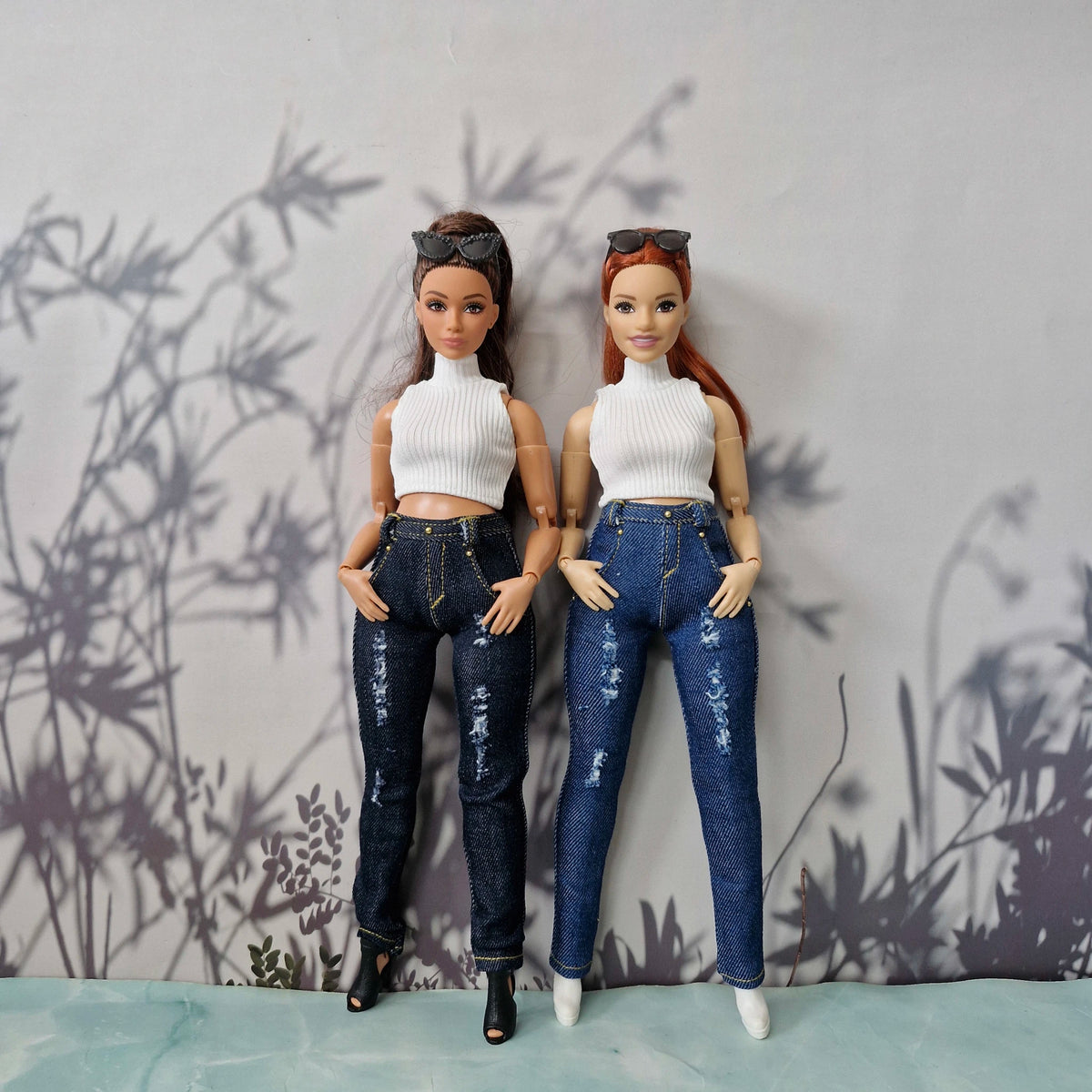 Two Curvy Barbie dolls modeling handmade white sleeveless tops and distressed jeans.