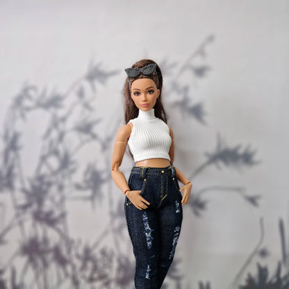 Close up of a brunette Curvy Barbie wearing a white high-neck top and dark blue distressed jeans.