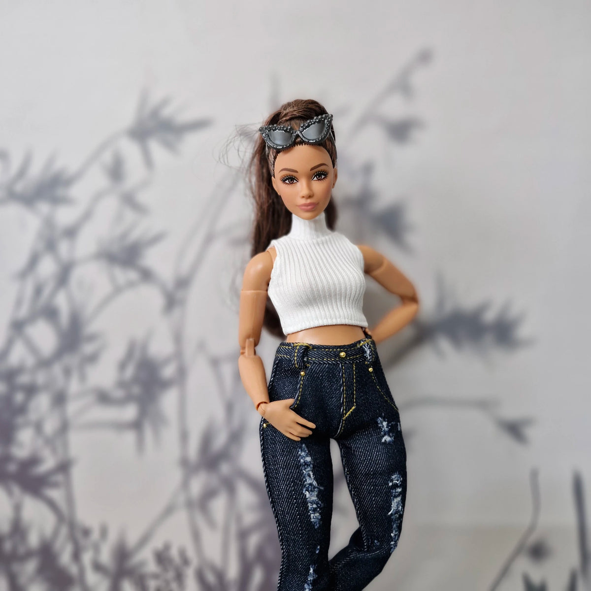 1/6 scale Curvy fashion doll posing in a white ribbed sleeveless top and distressed jeans.