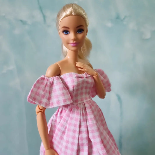 Barbie doll wearing pink gingham dress with puffy off-shoulder sleeves