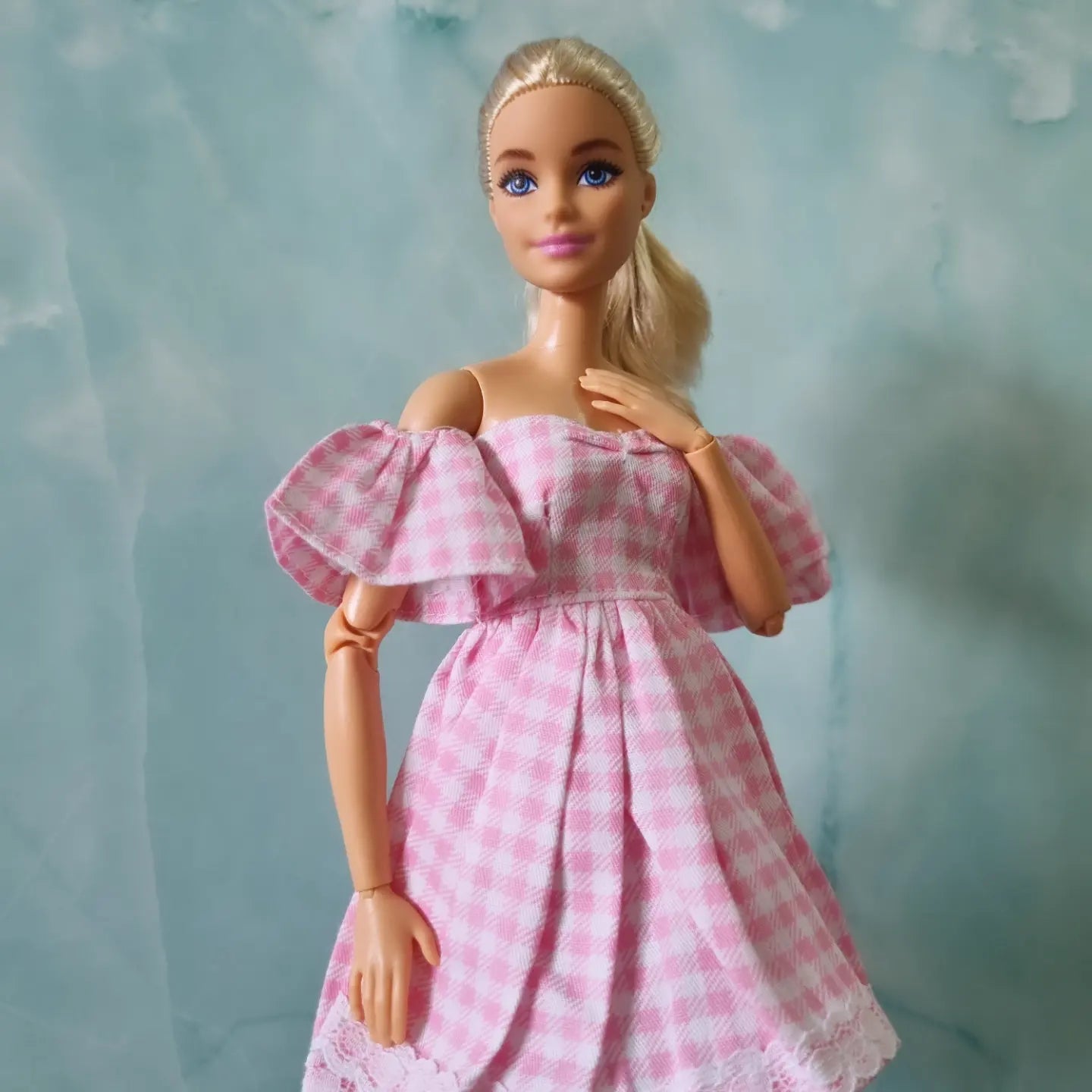 Close-up of Barbie in vintage-style pink checkered dress with lace trim