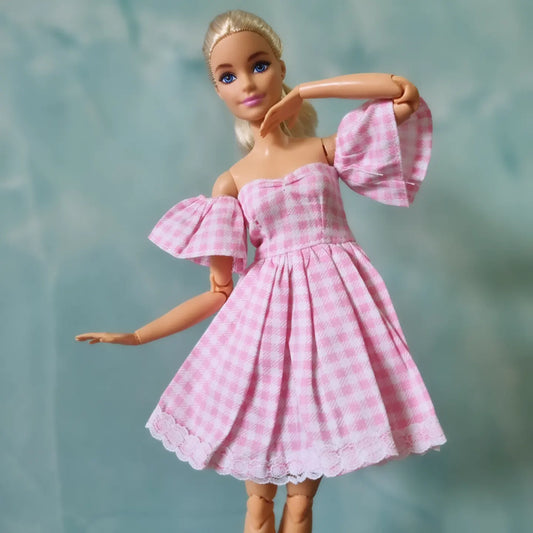 Elegant Barbie doll in pink gingham dress with lace details and puffy sleeves