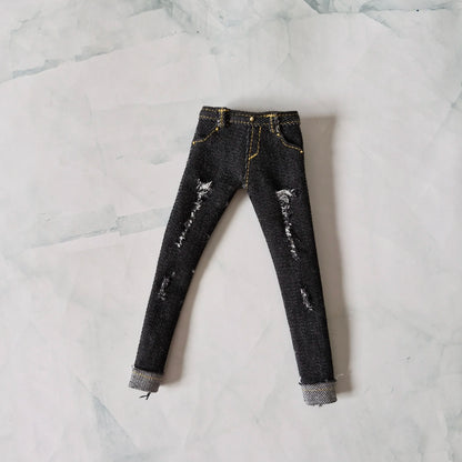 Flat lay view of black distressed skinny jeans with yellow stitching for Barbie dolls
